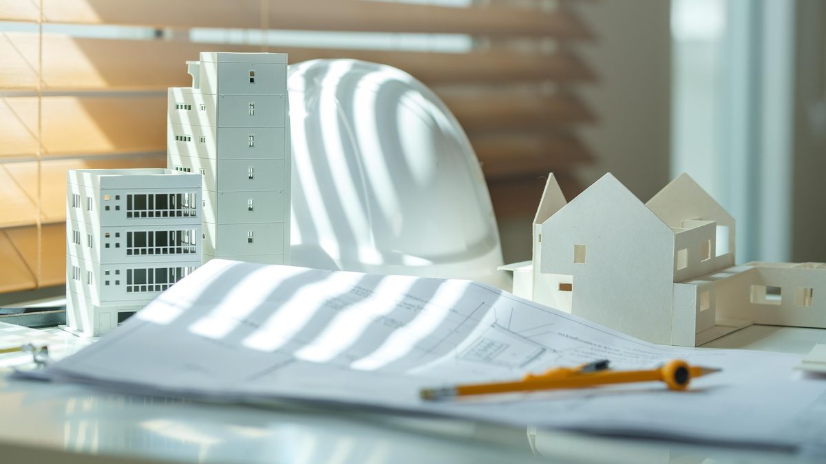 Architectural models, hard hat and construction drawings